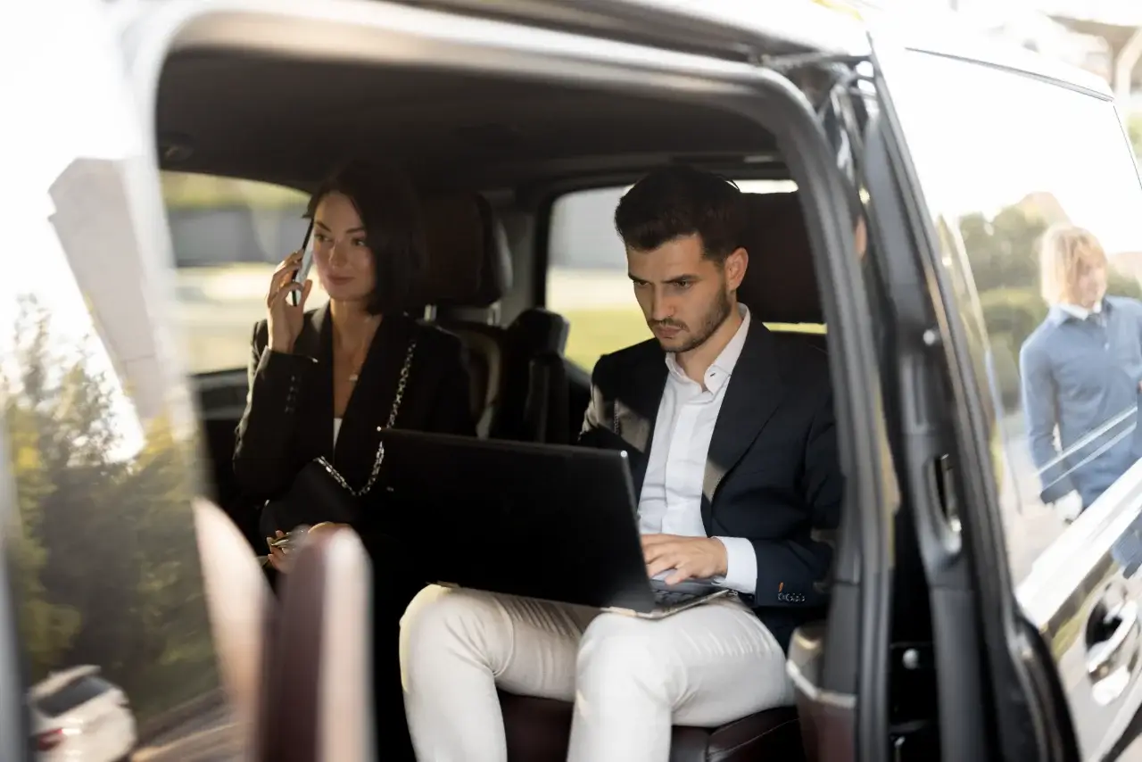 Cadres en déplacement professionnel travaillant à l’arrière d’un van avec chauffeur privé - Sam Ramène, Loire