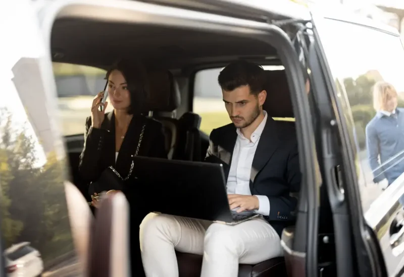 Cadres en déplacement professionnel travaillant à l’arrière d’un van avec chauffeur privé - Sam Ramène, Loire