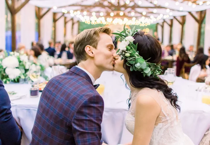 Mariés qui s’embrassent à leur réception sous les guirlandes - navette de mariage Loire